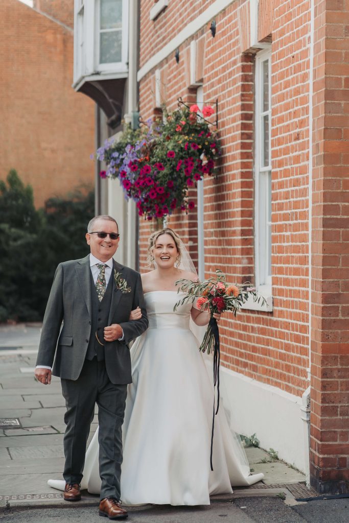 Bride and father walking down the street