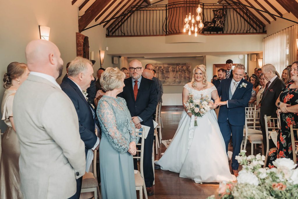 bride walking down the aisle at Nuthurst Grange wedding venue
