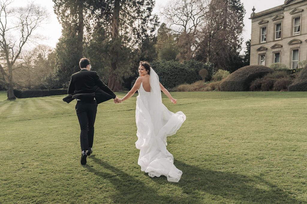 bride and groom running away from camera