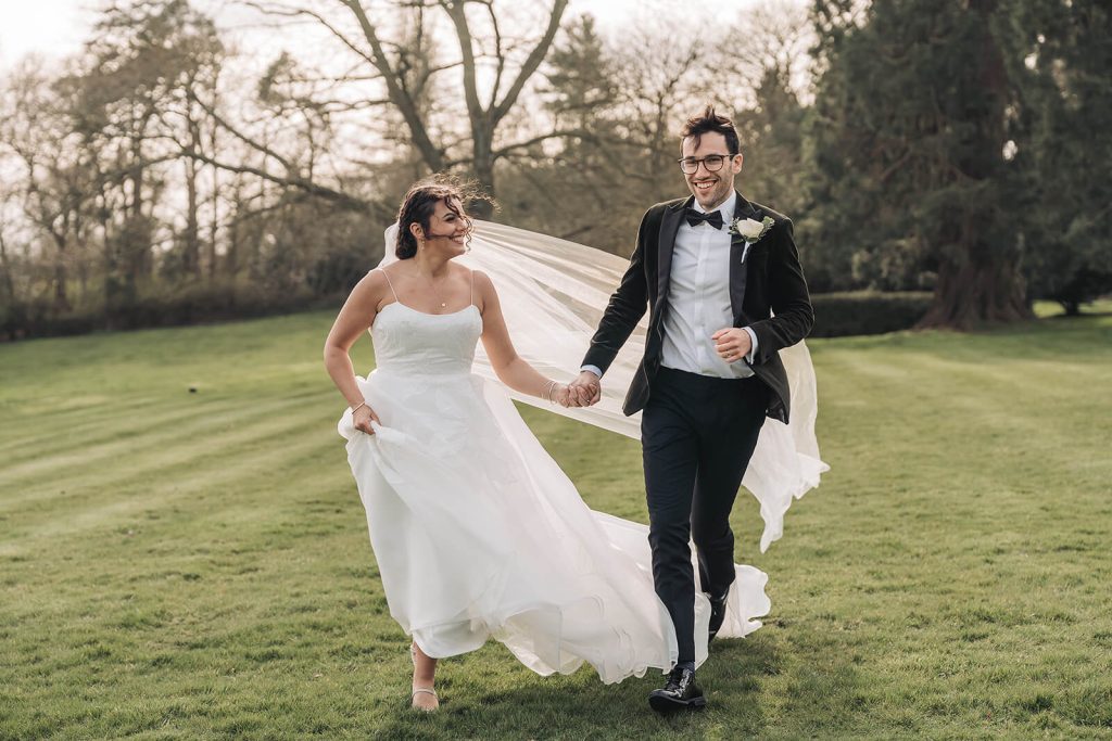 bride and groom running towards the camera smiling