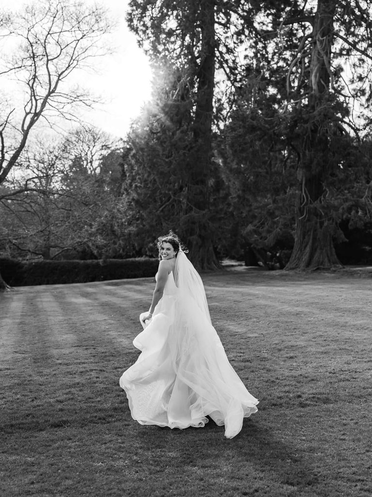 black and white photo of bride running away from camera