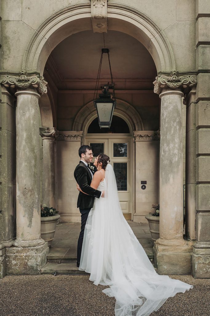 bride and groom hugging outside entrance to Kilworth House
