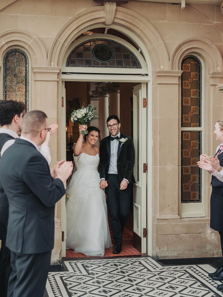 bride and groom entering wedding breakfast at Kilworth House