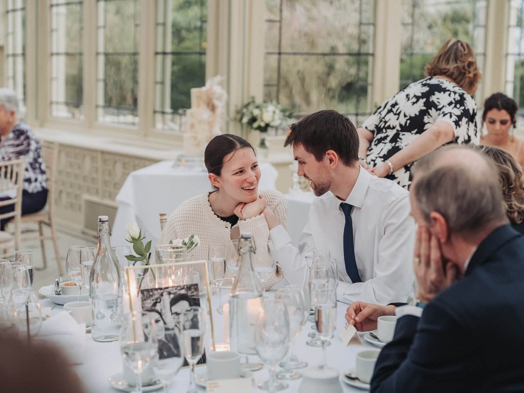 candid photo of wedding guests holding hands and smiling