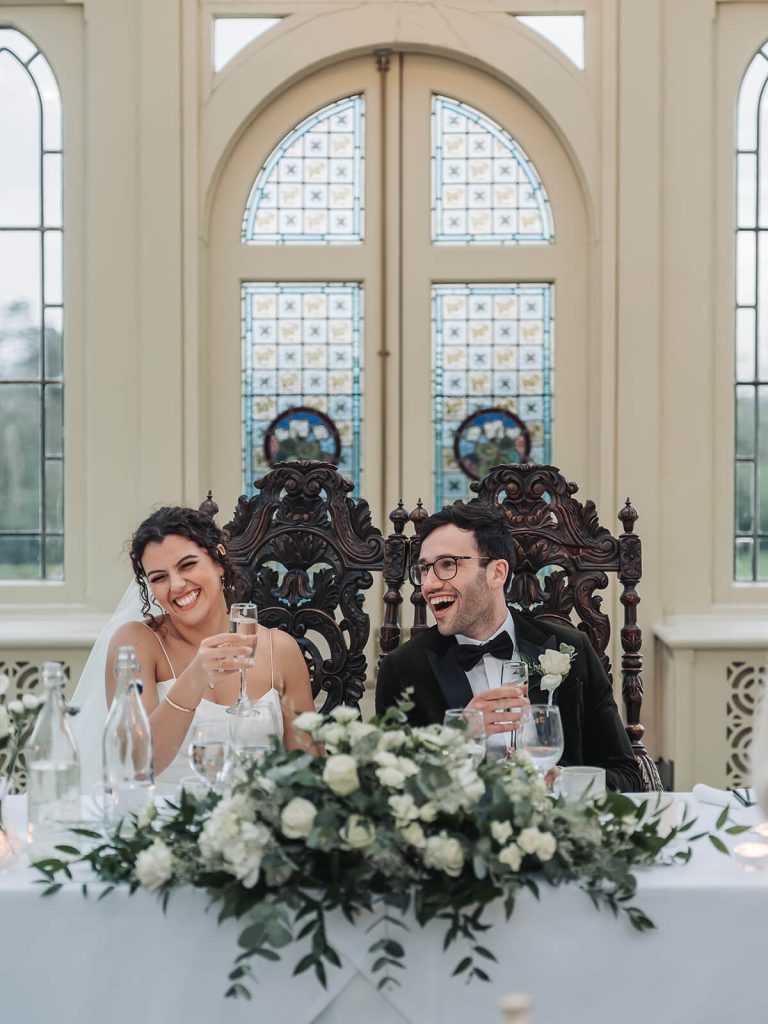 bride and groom laughing at wedding speech