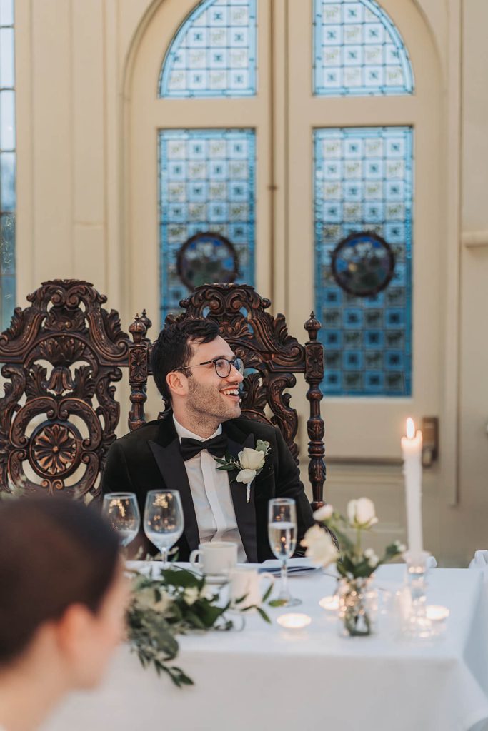 groom laughing during speeches at Kilworth House