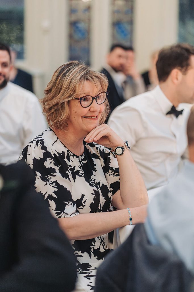 lady in black and white dress smiling listening to speeches