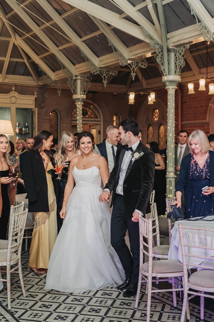 bride and groom walking onto dancefloor