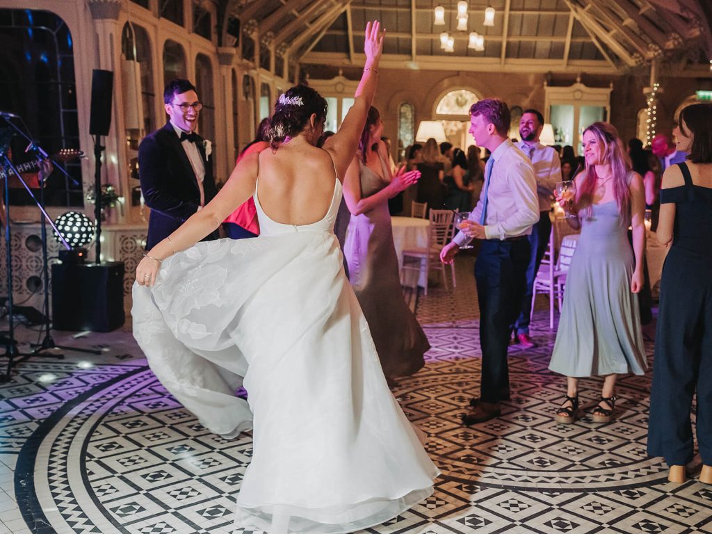 bride with hand up in air twirling dress