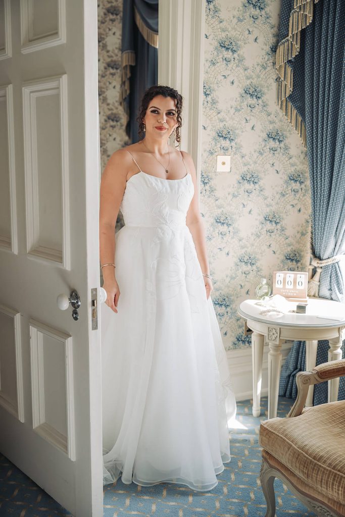 bride wearing wedding dress walking through doorway