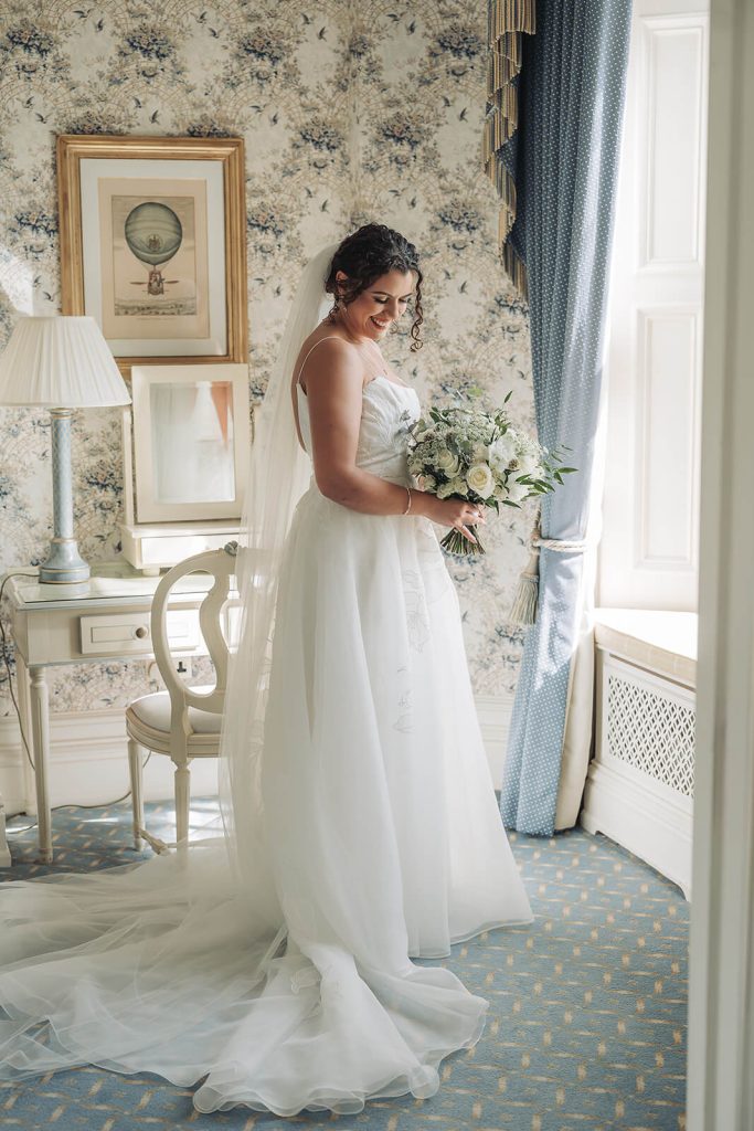 bride with white wedding bouquet gazing down