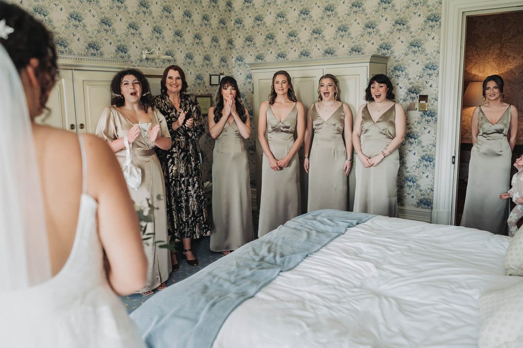 first look with bridesmaids looking shocked and emotional
