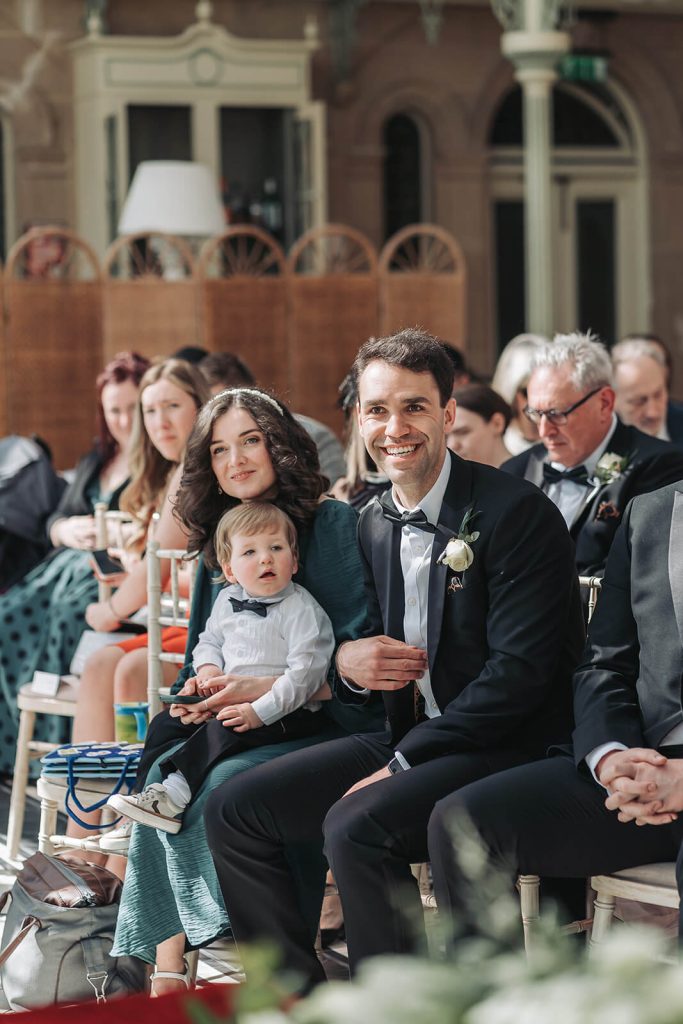 Candid photo of wedding guests waiting in ceremony