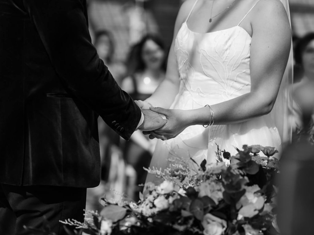 Black and white image of couple's hands holding