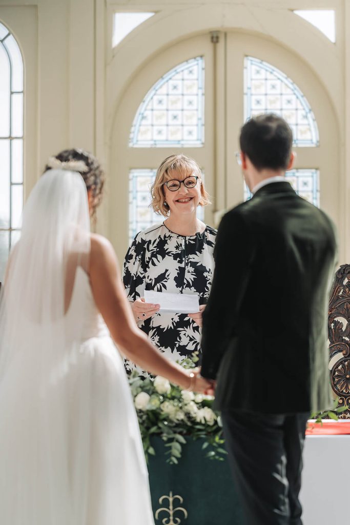 lady smiling at wedding couple in ceremony