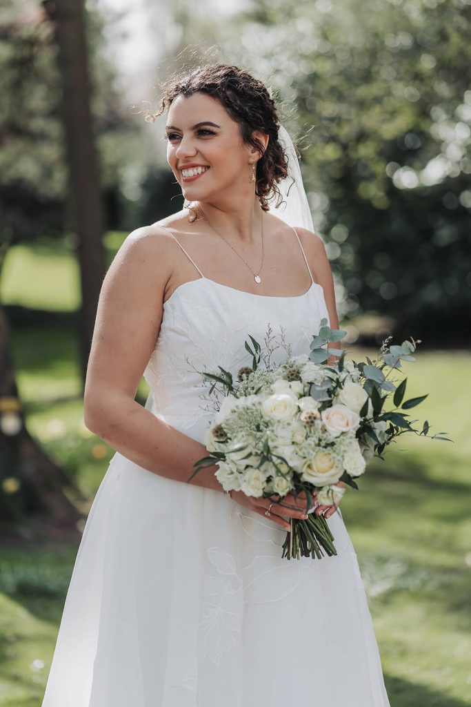 bridal portrait looking away from camera holding white bouquet