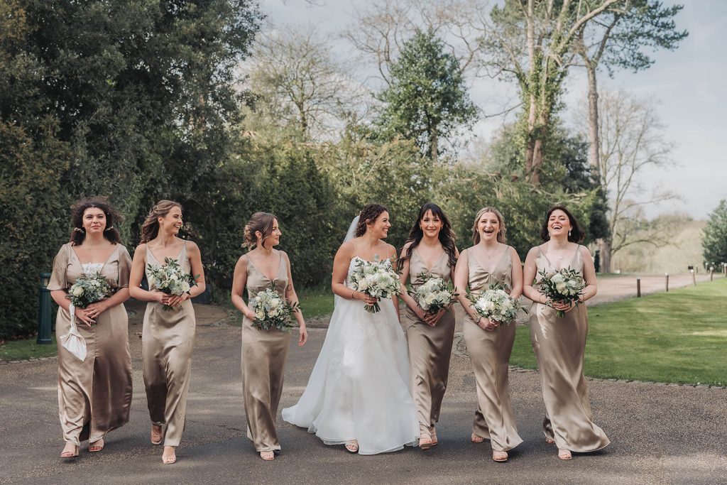 bride and bridesmaids walking and laughing at Kilworth House
