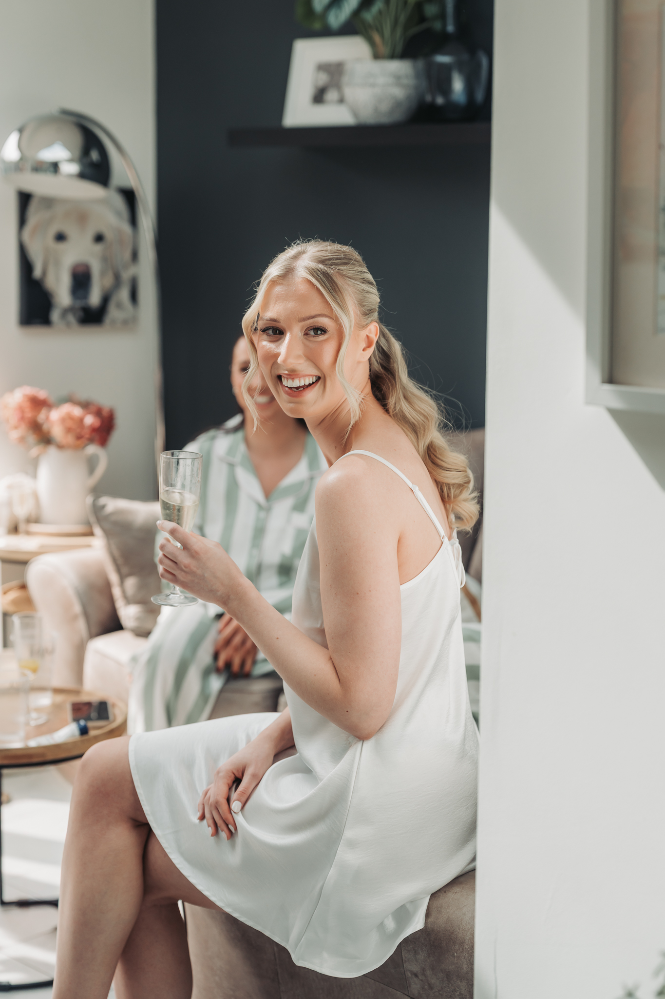 bride holding champagne dress laughing over her shoulder