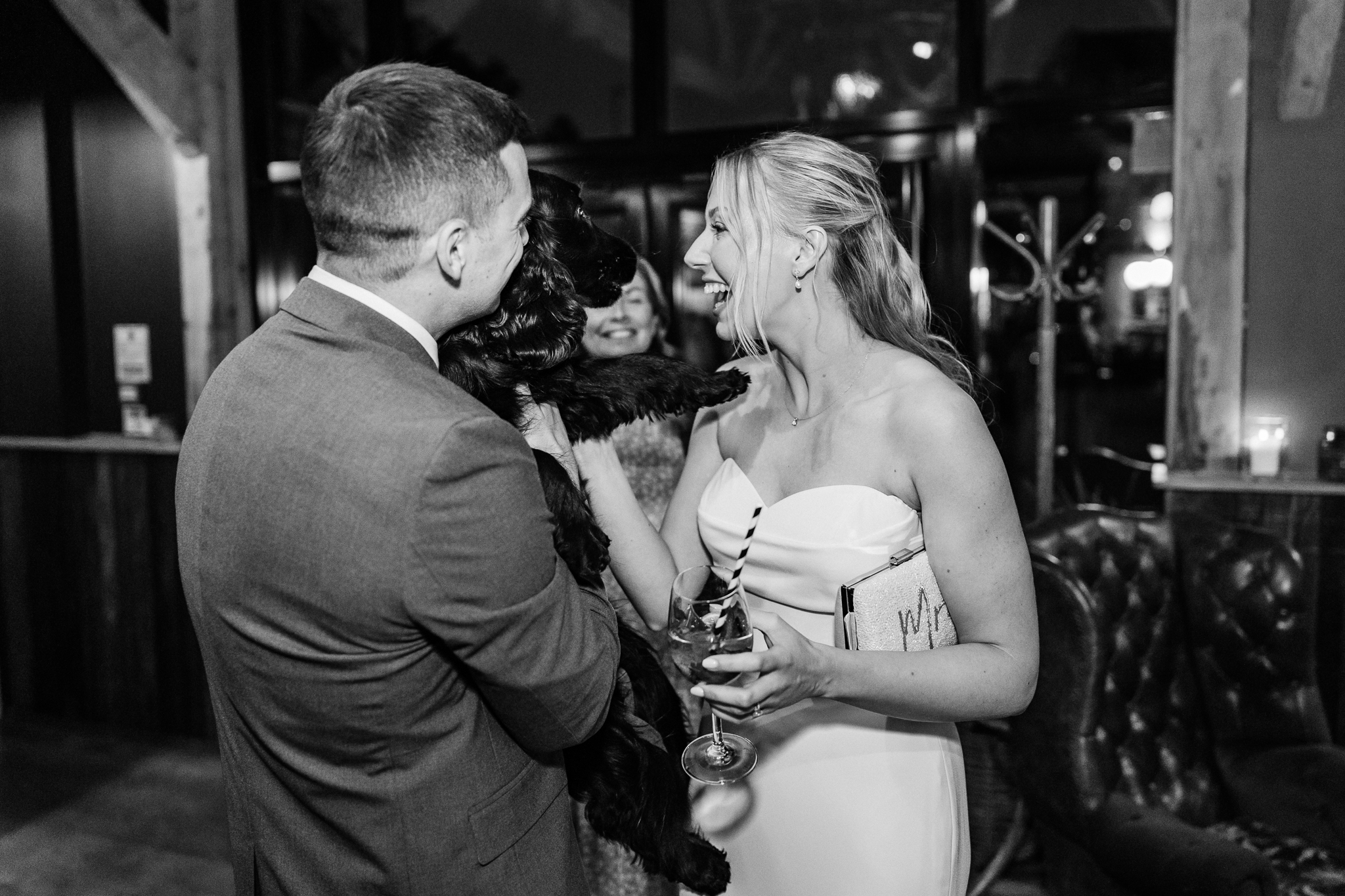 black and white photo of couple holding dog