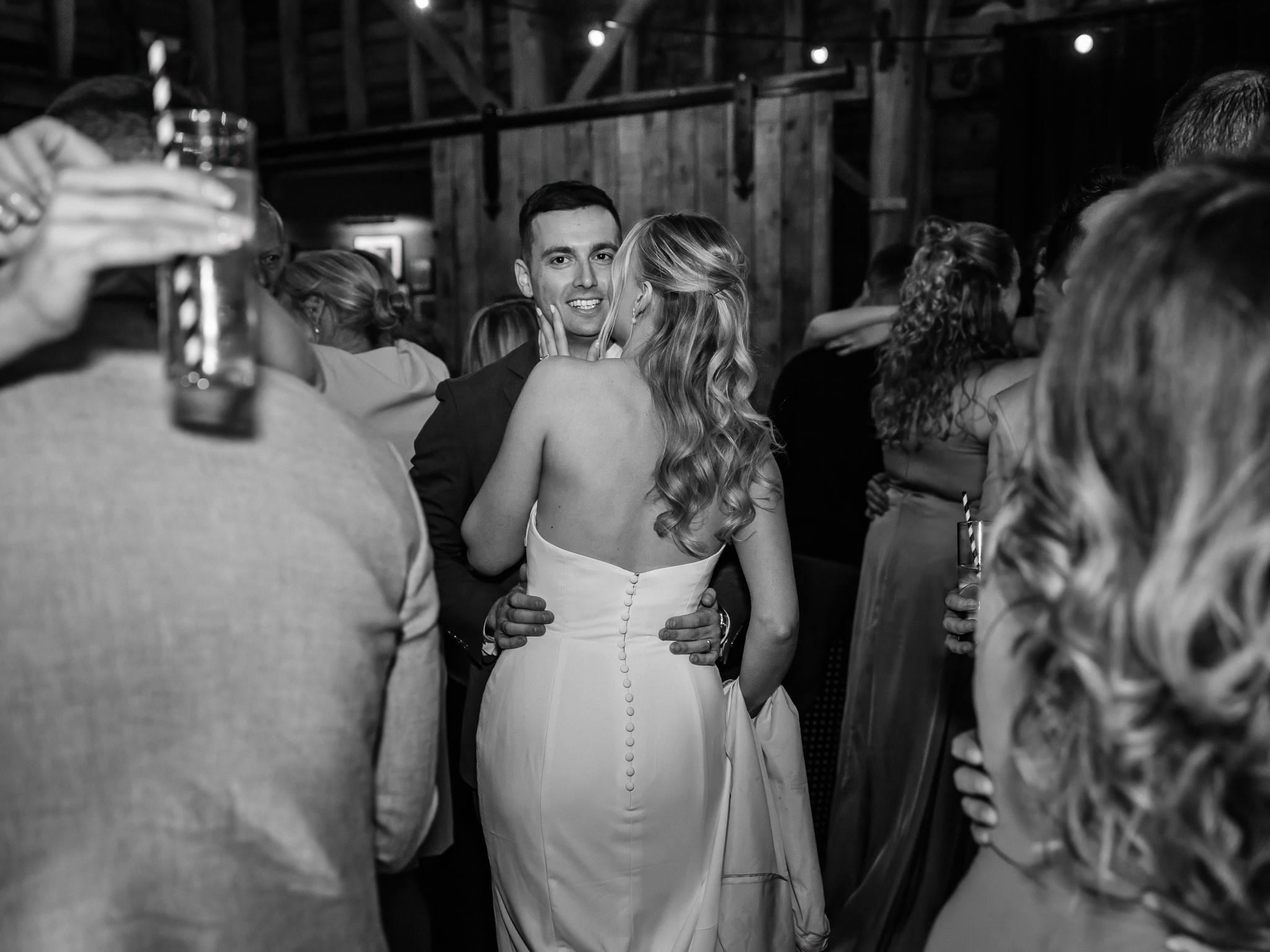 black and white photo of bride kissing grooms cheek