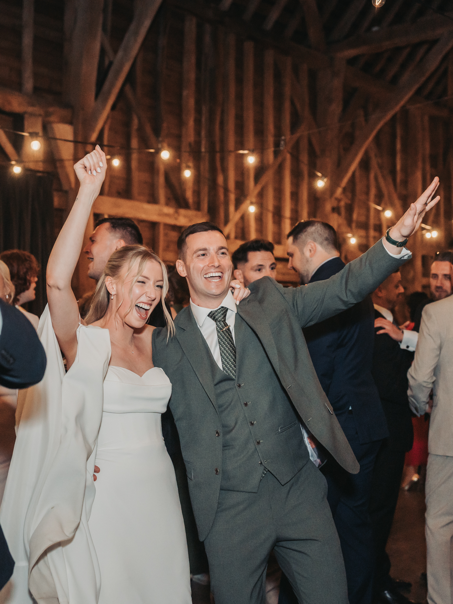 wedding couple arms in air celebrating on dancefloor