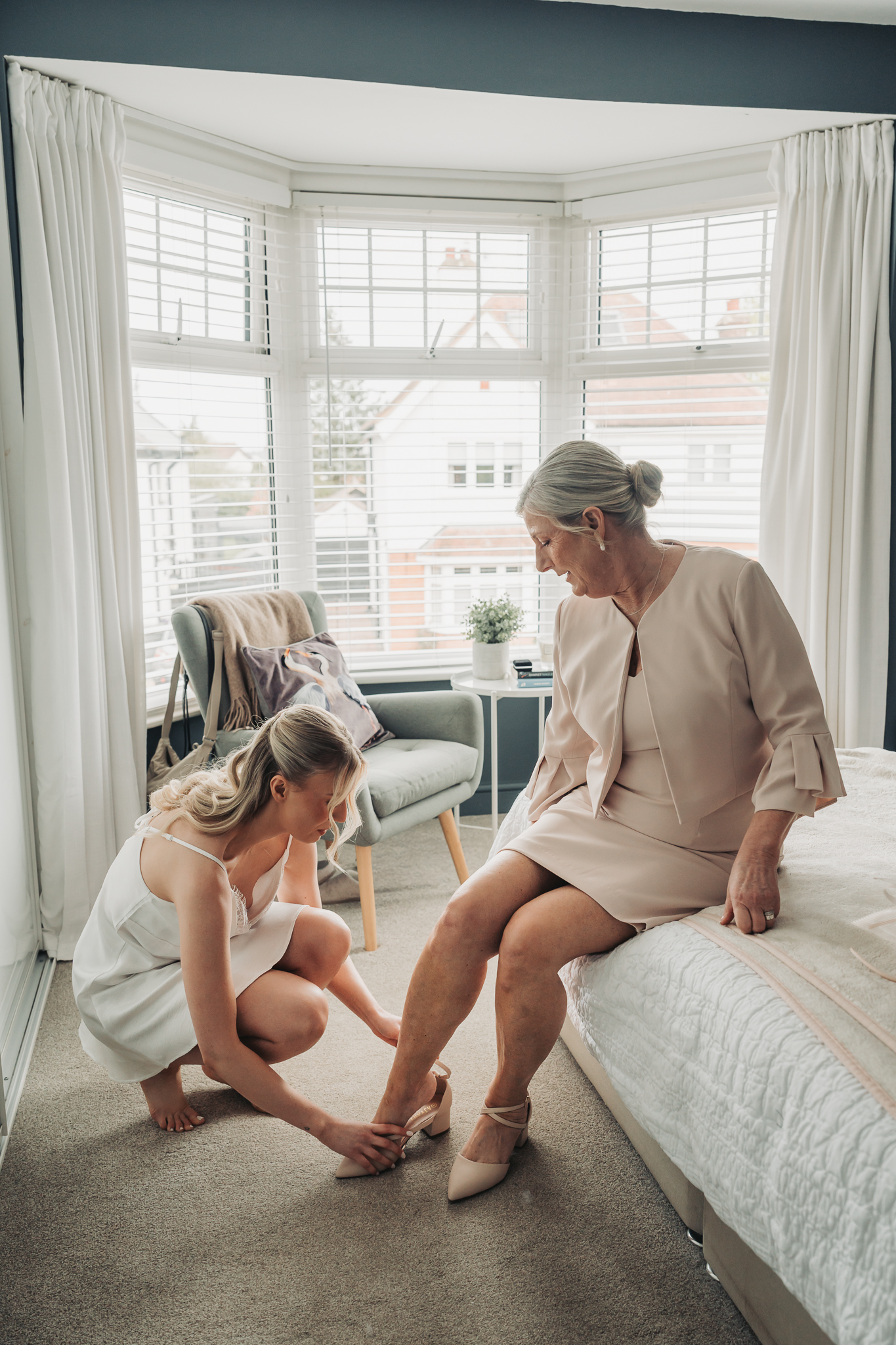 bride putting mums shoes on