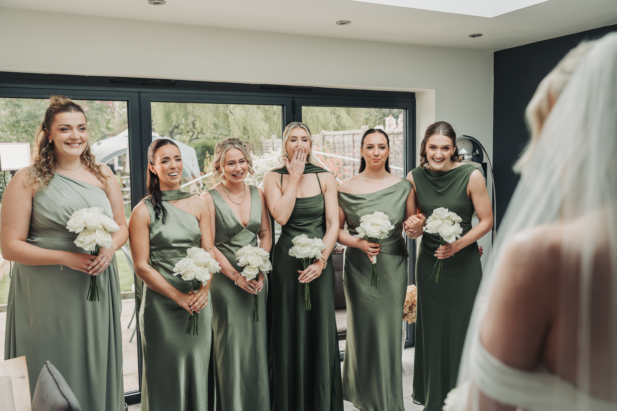 bride first look with bridesmaids wearing green dresses