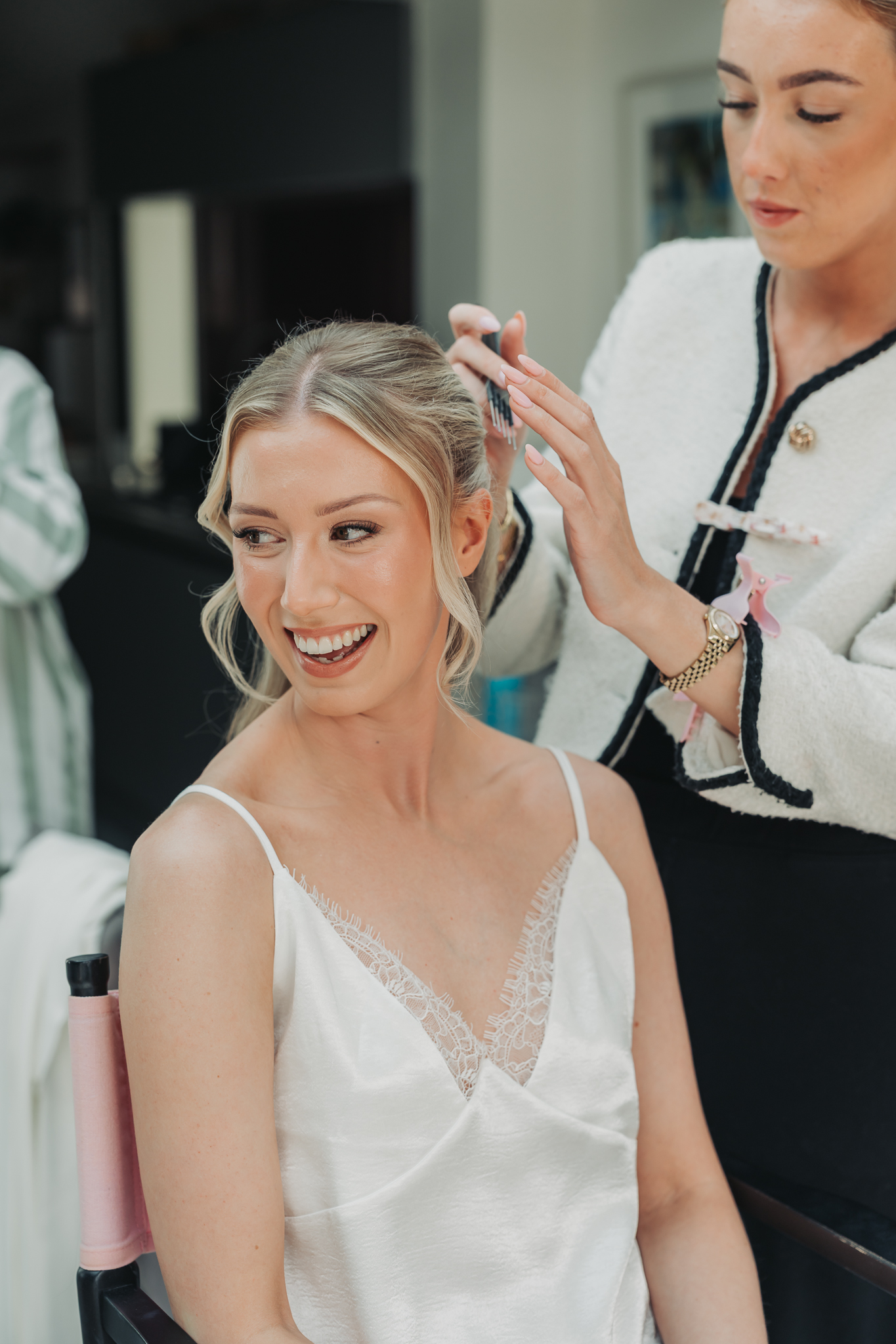 Bride smiling and laughing having her hair done at Hitchin wedding
