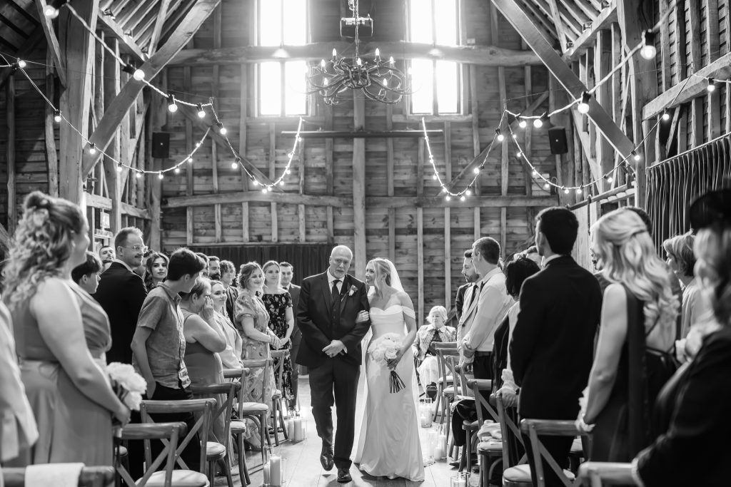 black and white photo of bride walking down the aisle with dad