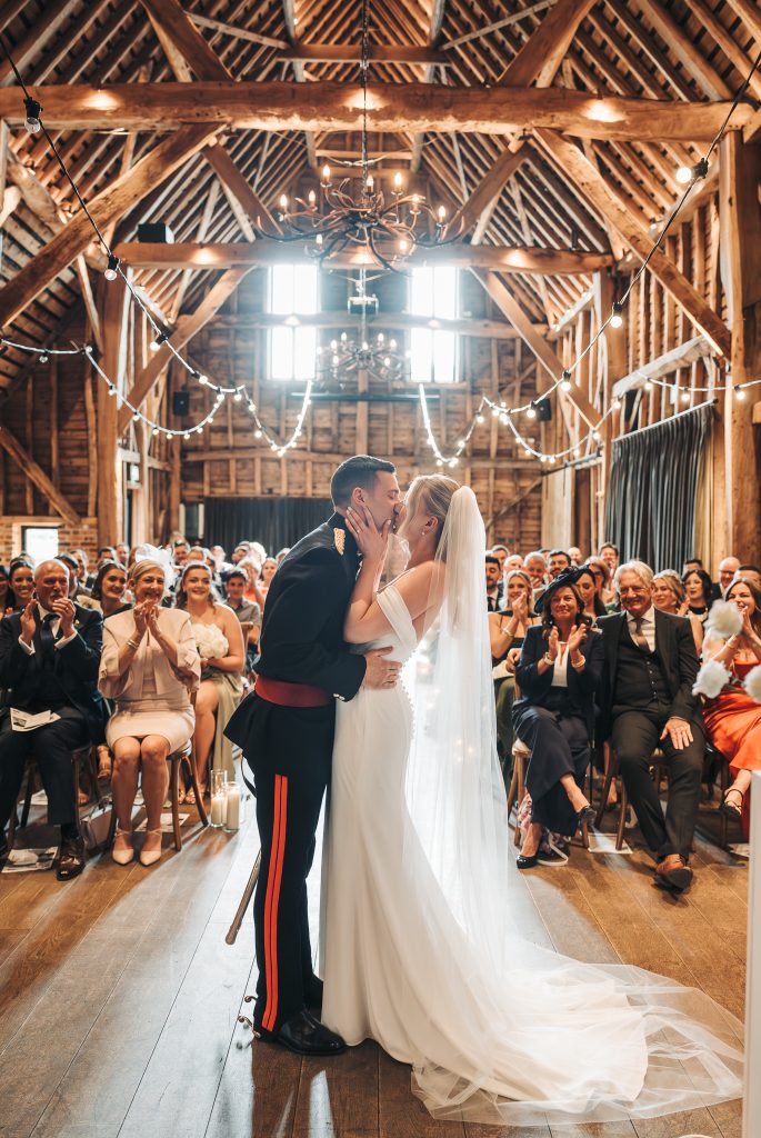 bride and grooms first kiss at barn at Redcoats