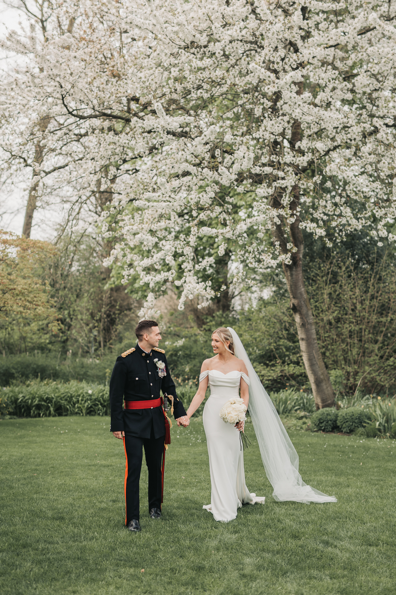 wedding ocuple under blossom tree at barn at Redcoats